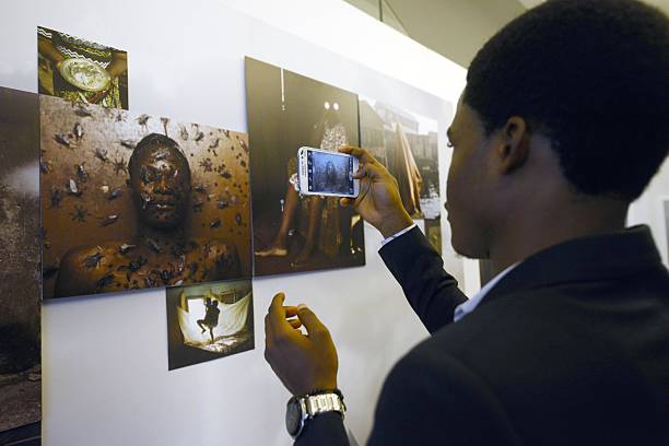 Art enthusiast takes photograph at a Lagos exhibition